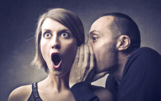Man telling an astonished woman a gossip